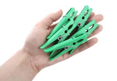 Woman holding green plastic clothespins on white background, closeup