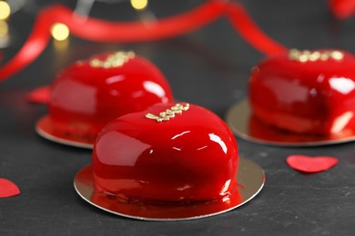 St. Valentine's Day. Delicious heart shaped cakes and confetti on black table, closeup