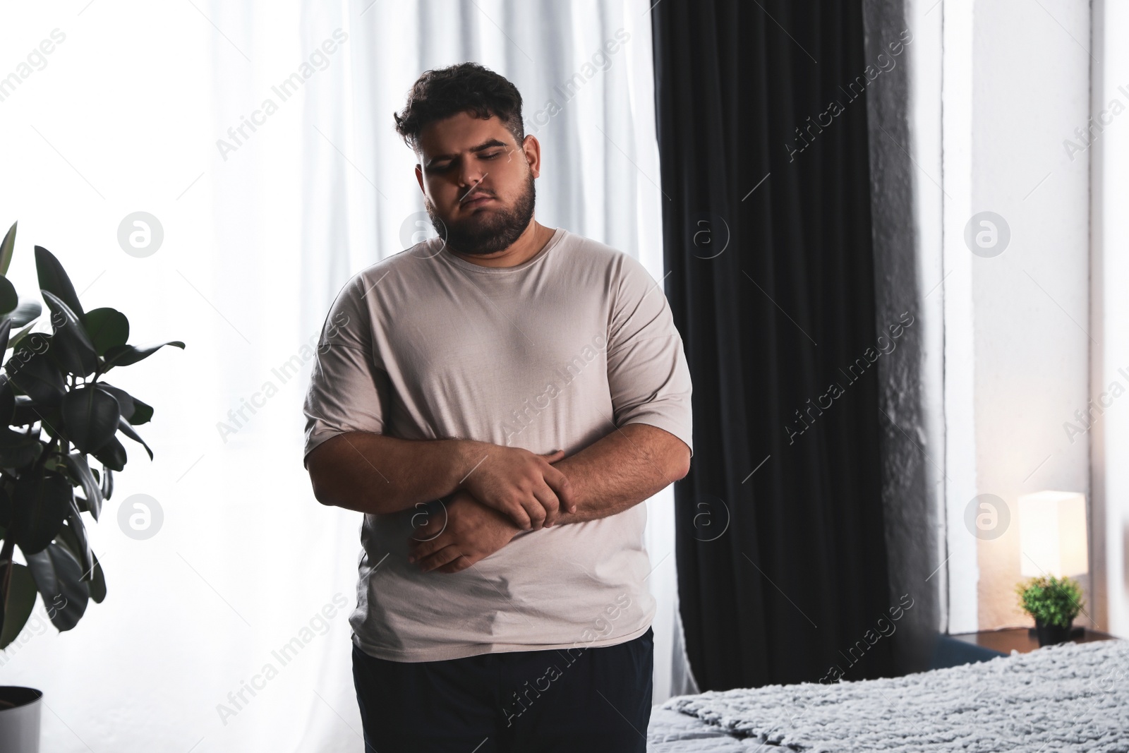 Photo of Overweight man suffering from depression at home