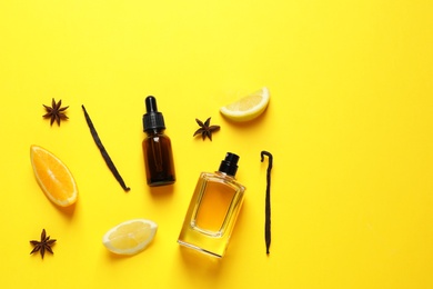 Flat lay composition with elegant perfume on yellow background, space for text