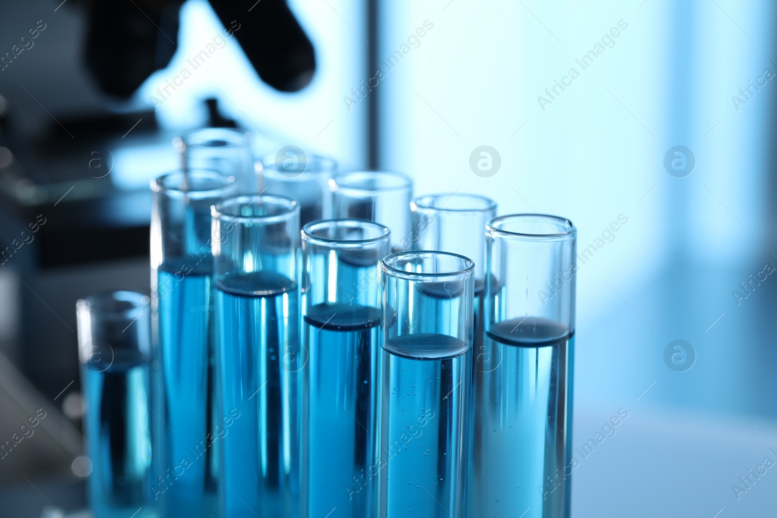 Photo of Test tubes with light blue liquid in laboratory, closeup