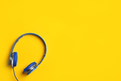 Stylish headphones on color background, top view. Space for text