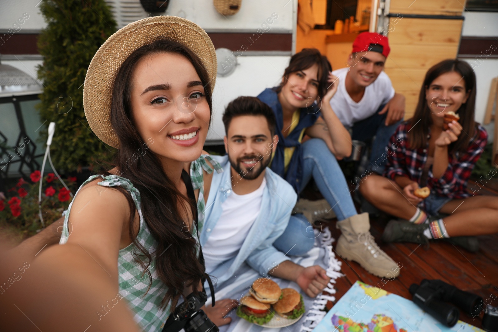 Photo of Happy friends taking selfie near motorhome. Camping season