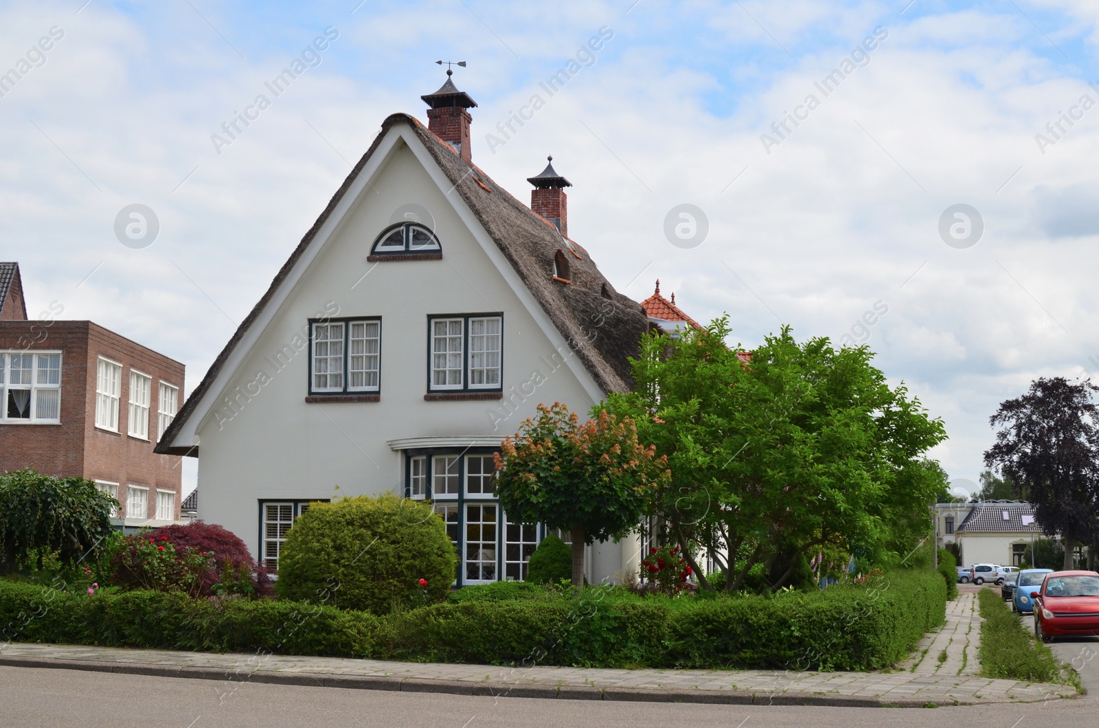 Photo of Exterior of beautiful house surrounded by green trees and shrubs