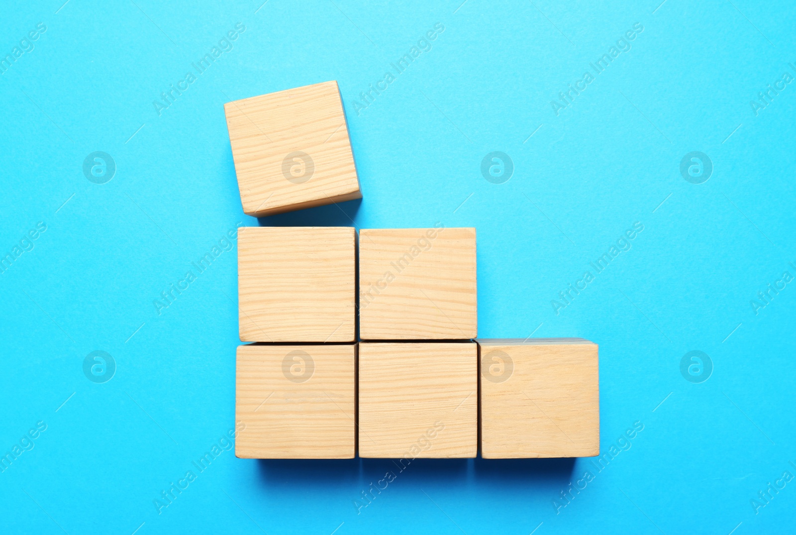 Photo of Blank cubes on light blue background, flat lay with space for text. Idea concept