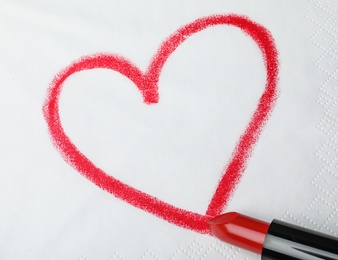 Photo of Drawing heart with lipstick on paper napkin, top view