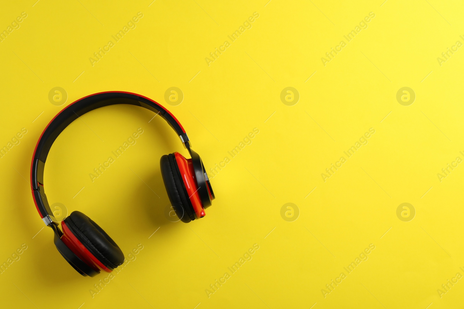 Photo of Wireless headphones on color background, top view. Space for text