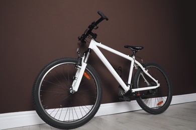 Photo of Modern sport mountain bike near brown wall