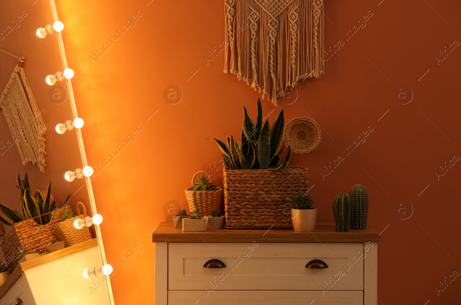 Photo of Large mirror with light bulbs and chest of drawers in stylish room interior