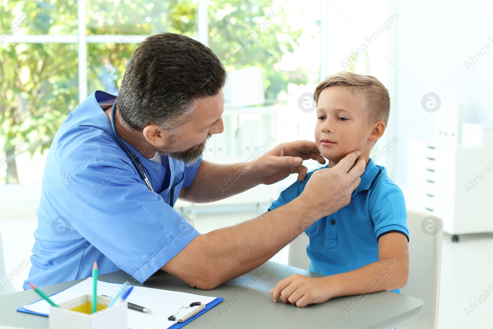 Photo of Male medical assistant examining child in clinic