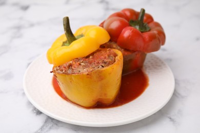 Photo of Delicious stuffed bell peppers served on white marble table