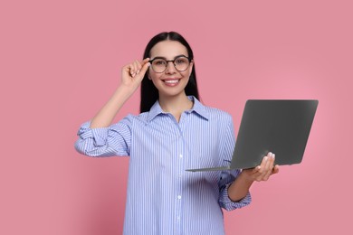 Photo of Happy woman with laptop on pink background