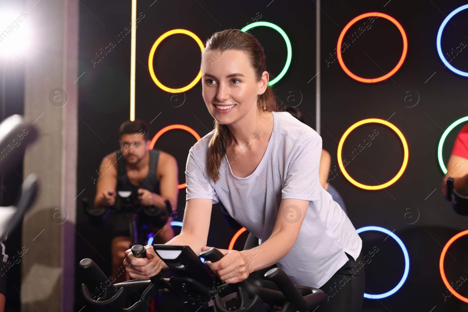 Photo of Group of people training on exercise bikes in fitness club