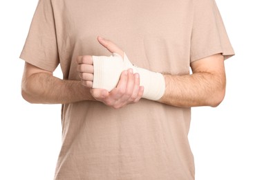 Man with hand wrapped in medical bandage on white background, closeup