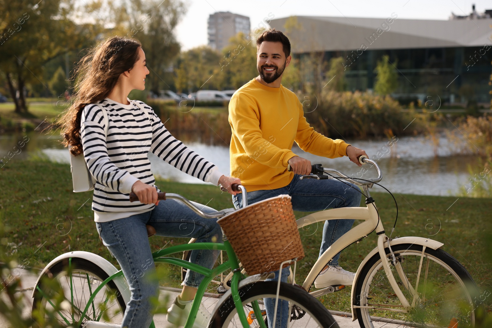 Photo of Beautiful young couple riding bicycles in park