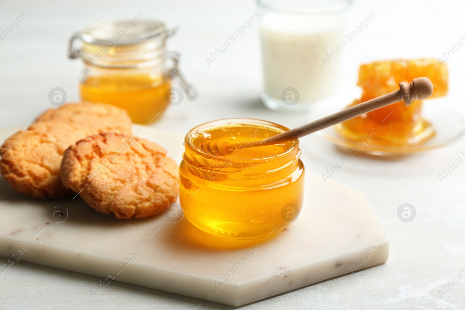 Photo of Fresh honey and cookies on white table