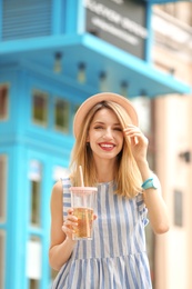 Photo of Young woman with cup of tasty lemonade outdoors