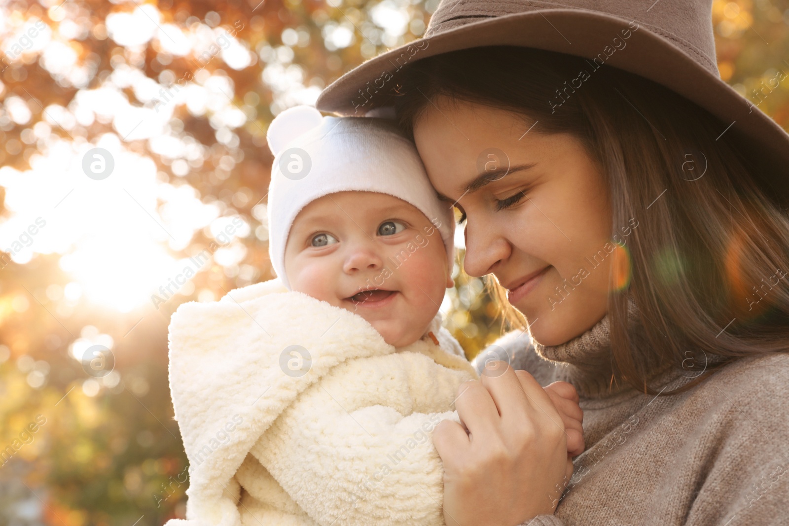 Photo of Happy mother with her baby daughter outdoors on autumn day