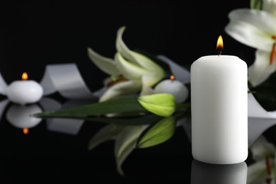 Burning candle on black mirror surface in darkness, closeup with space for text. Funeral symbol
