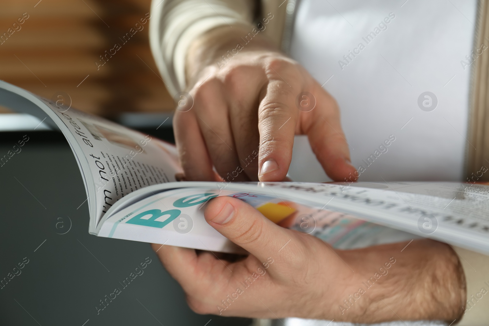 Photo of Man reading modern magazine indoors, closeup view