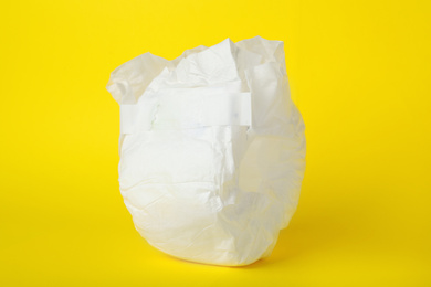 Photo of Baby diaper on yellow background, closeup. Child's underwear
