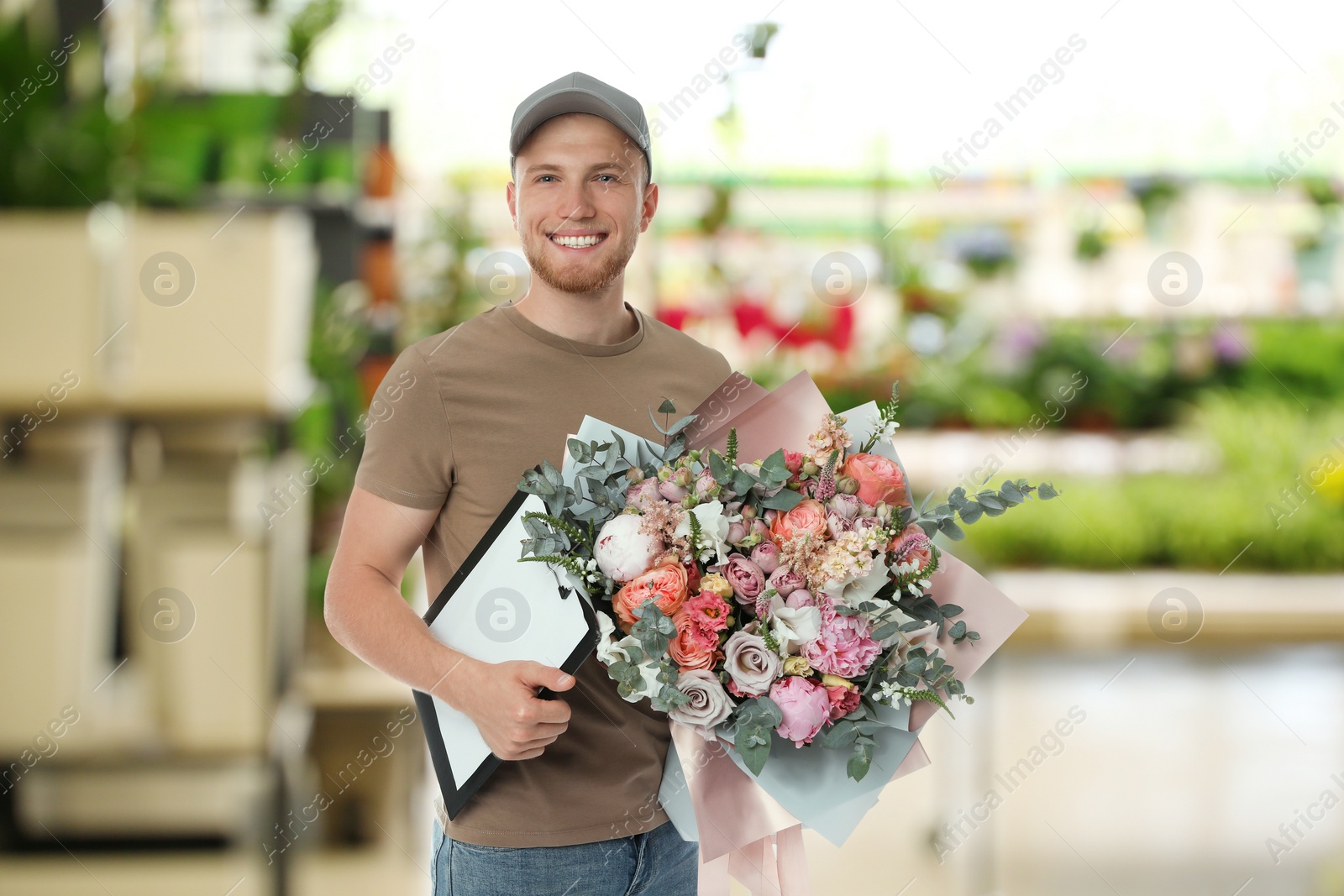 Image of Delivery man with beautiful bouquet in flower shop 