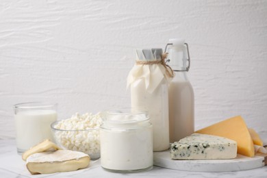 Photo of Different fresh dairy products on white marble table