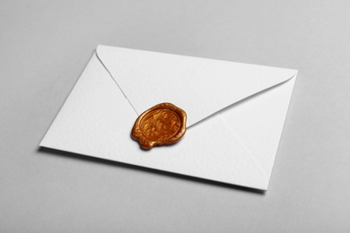 Photo of White envelope with wax seal on grey background