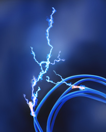 Image of Sparking cables on dark blue background, closeup. Electrician's supply