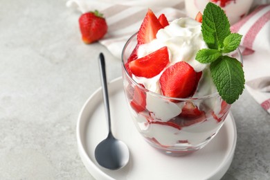 Photo of Delicious strawberries with whipped cream served on light grey table, closeup. Space for text