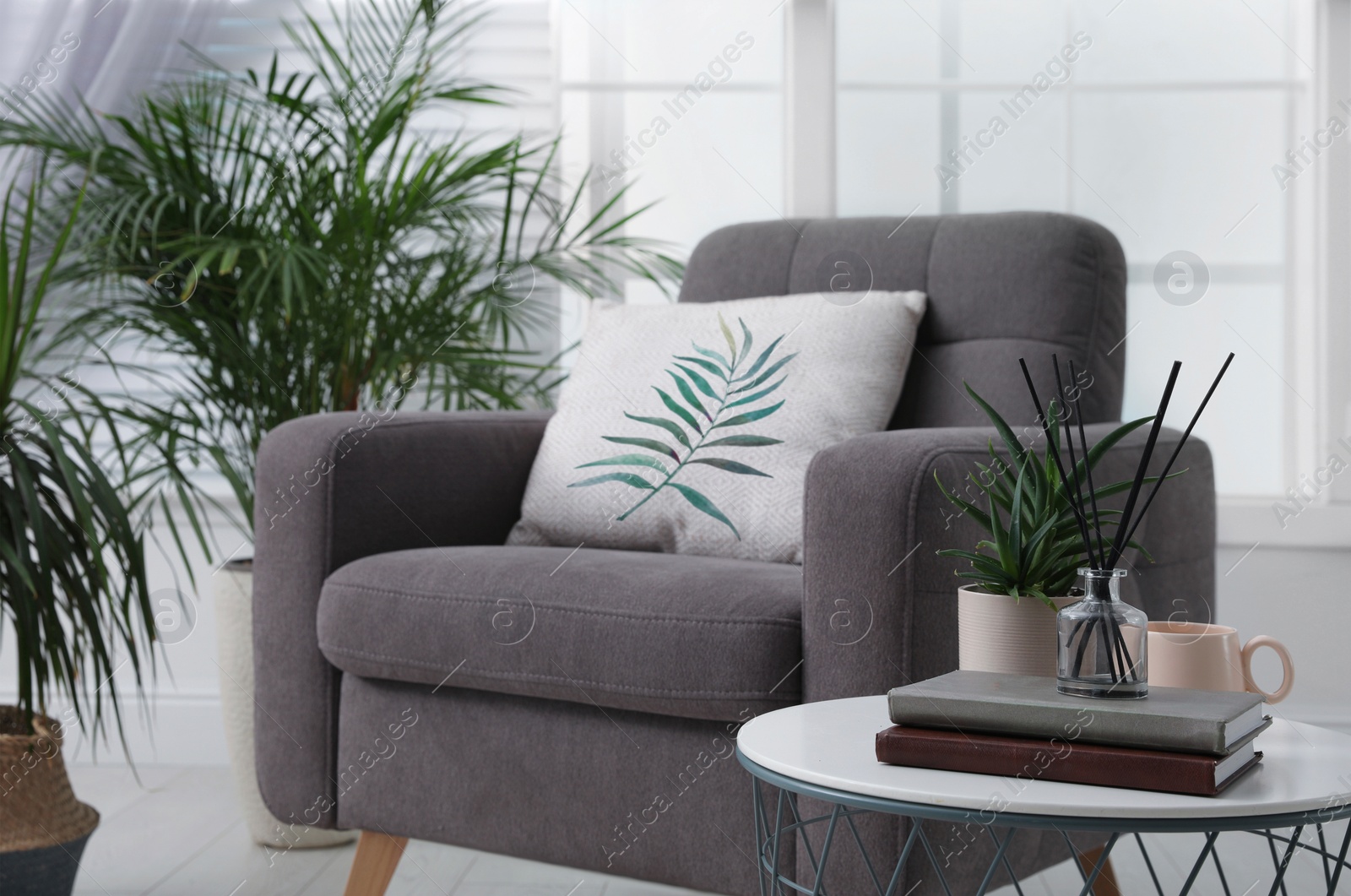 Image of Soft pillow with printed tropical leaf on armchair indoors