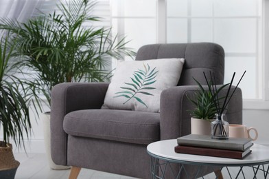 Image of Soft pillow with printed tropical leaf on armchair indoors