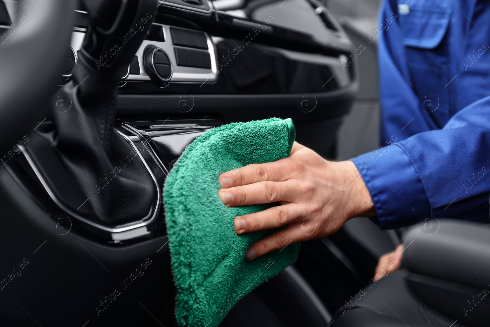 Photo of Car wash worker cleaning automobile interior, closeup