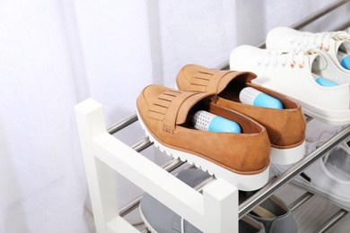 Photo of Shoes with capsule fresheners on rack in room