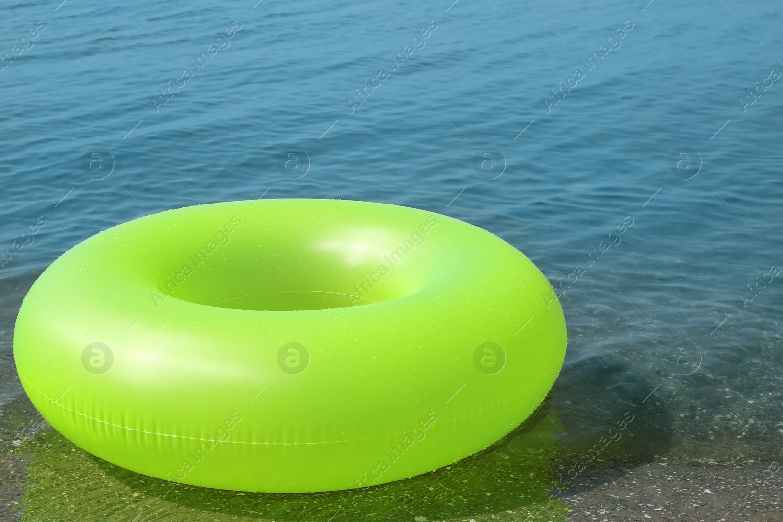 Photo of Bright inflatable ring floating on sea water. Summer vacation