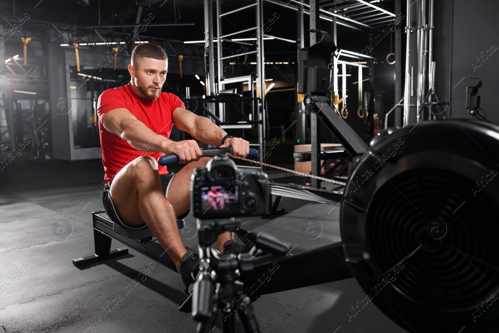 Photo of Man recording workout on camera at gym. Online fitness trainer