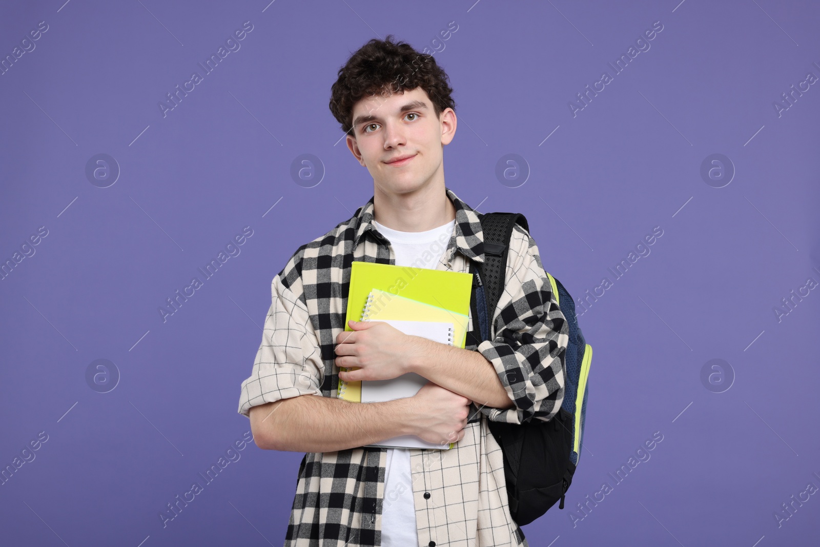 Photo of Portrait of student with backpack and notebooks on purple background