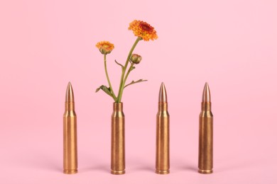 Photo of Bullets and beautiful chrysanthemum flowers on pink background