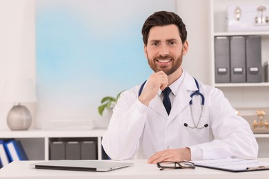 Photo of Medical consultant with stethoscope at table in clinic, space for text