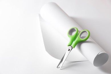 Green scissors and paper on white background. Space for text