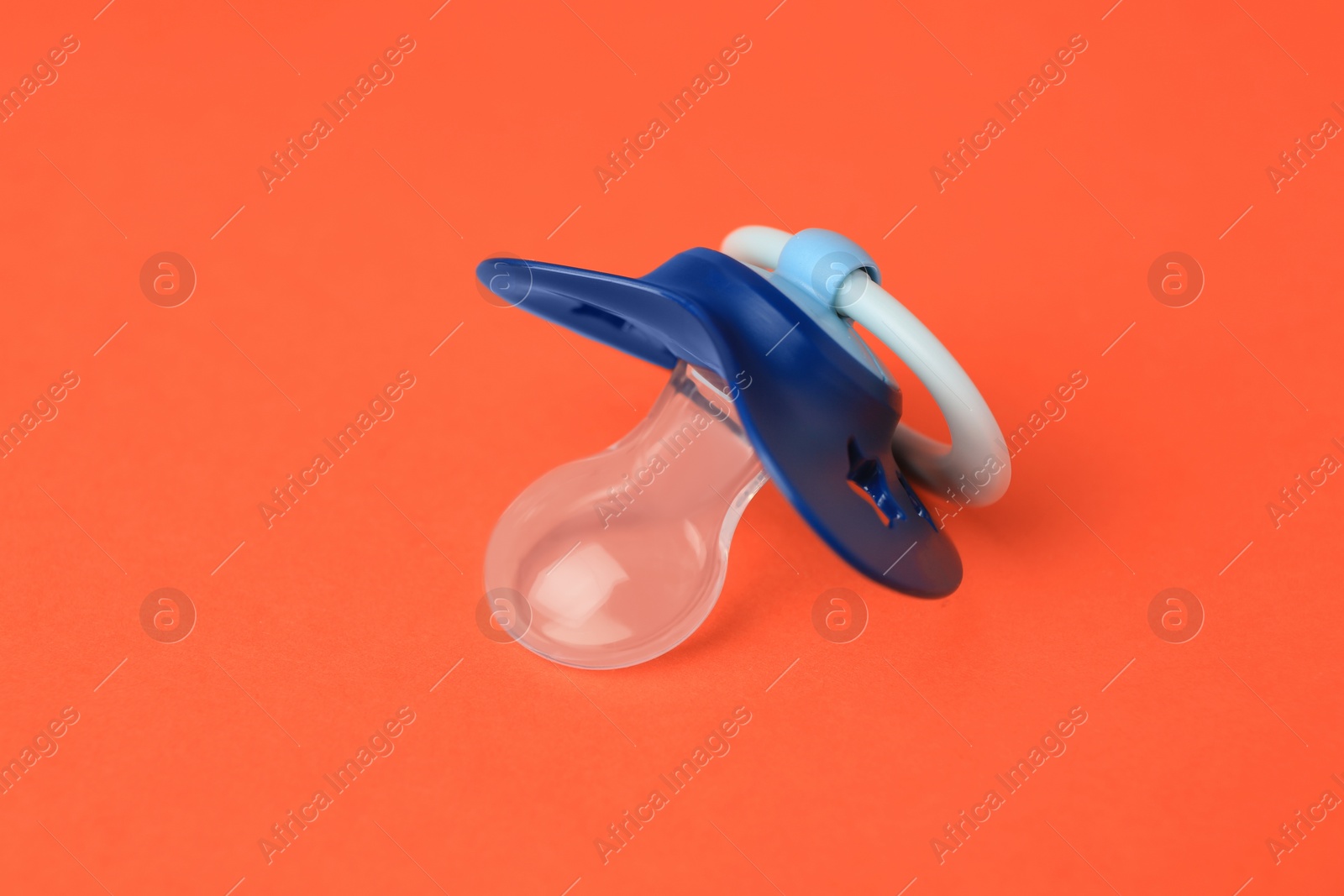 Photo of One blue baby pacifier on orange background