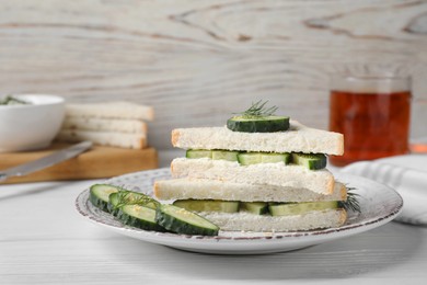 Photo of Tasty cucumber sandwiches with sesame seeds and dill on white wooden table