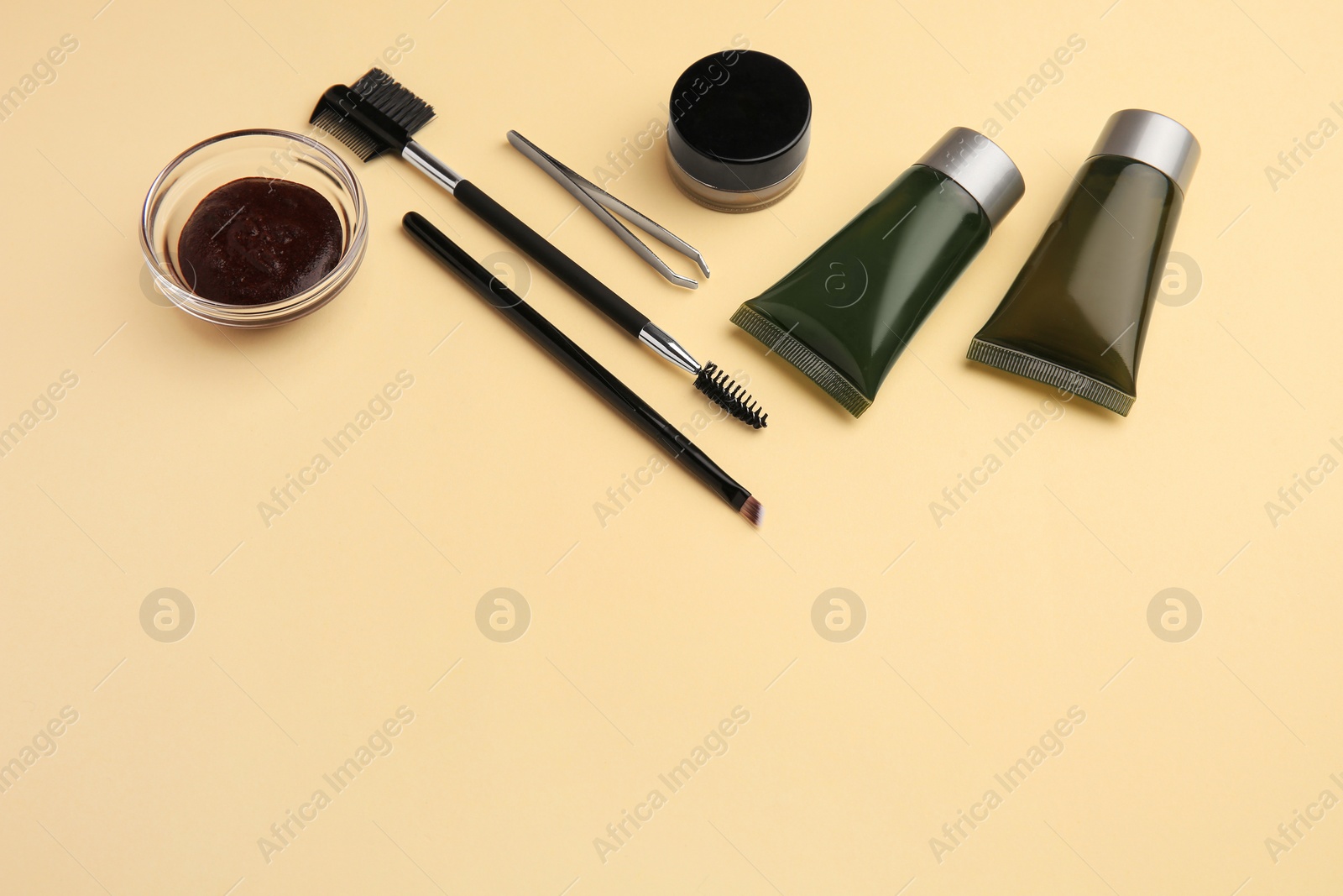 Photo of Eyebrow henna and tools on beige background. Space for text