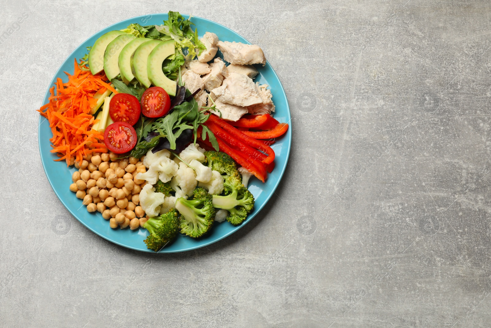 Photo of Balanced diet and healthy foods. Plate with different delicious products on grey table, top view. Space for text