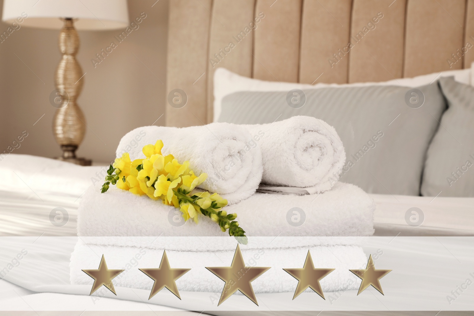 Image of Fresh white towels with flower on bed in five star hotel room