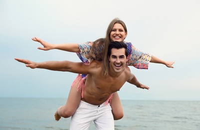 Happy young couple having fun on sea beach