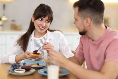 Photo of Happy couple having tasty breakfast at home, selective focus