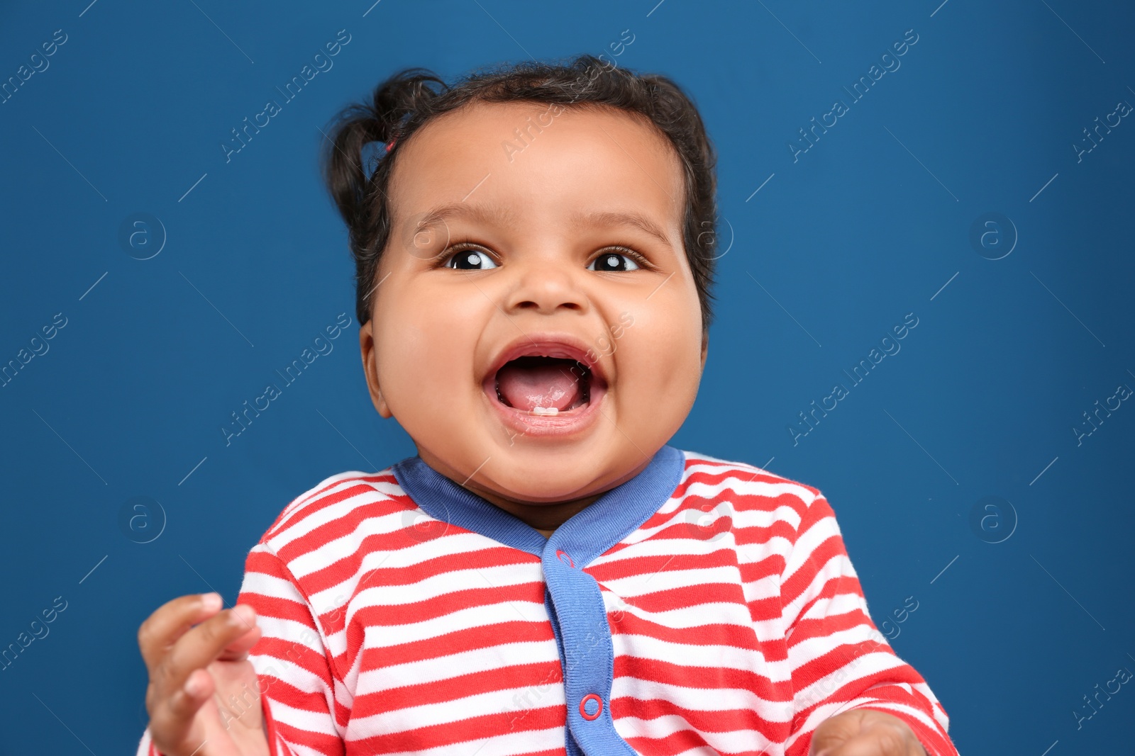 Photo of Cute African American baby on blue background