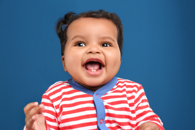 Photo of Cute African American baby on blue background
