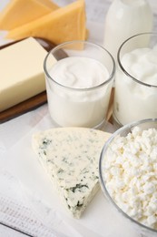 Different fresh dairy products on white wooden table, closeup